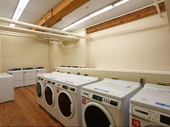 A room filled with lots of white washing machines